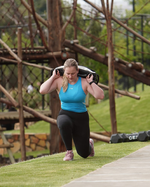 Personal training client doing sandbag lunges